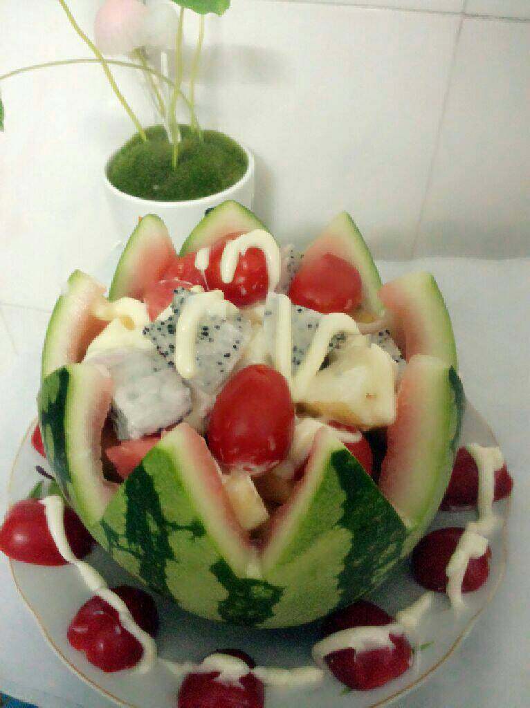 水果沙拉,把所有备好的水果全部放入西瓜壳里 在在盘外摆上切对半的圣女果  在把<a style='color:red;display:inline-block;' href='/shicai/ 4856'>沙拉酱</a>淋在面上即可完成  如图