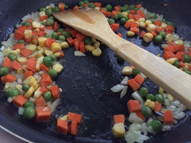 鲜虾菠萝饭,如图，炒香洋葱碎后加入蔬果.炒2分钟