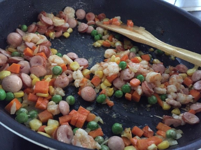 鲜虾菠萝饭,如图加入虾仁和火腿一起炒熟后放菠萝丁.