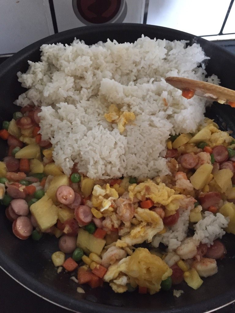 鲜虾菠萝饭,如图把煮好摊凉的白饭，倒入拌炒，淋上少许生抽，撒上少许盐，拌匀。