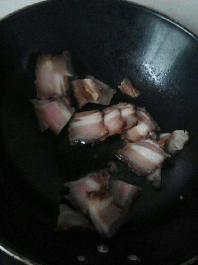 腊肉炒苦瓜,锅里放入适量的油，放入腊肉，煸炒至腊肉金黄