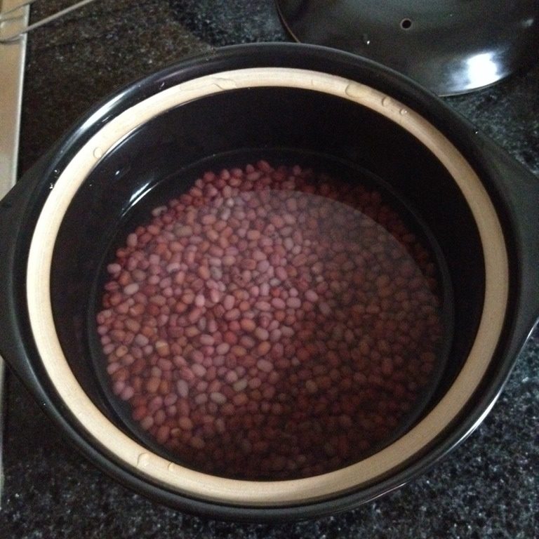 蜜红豆,把红豆装进砂锅,加入高过红豆1厘米左右的清水,盖上盖子烧开后转小火煮约40分钟。