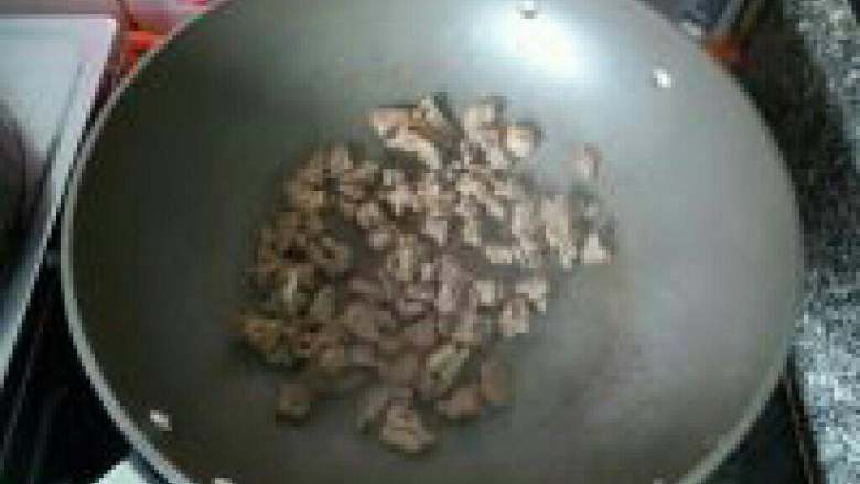 孜然羊肉,锅内不放油烧热，放入羊肉煸炒。煸炒至水分收干，再加入食用油炒香。