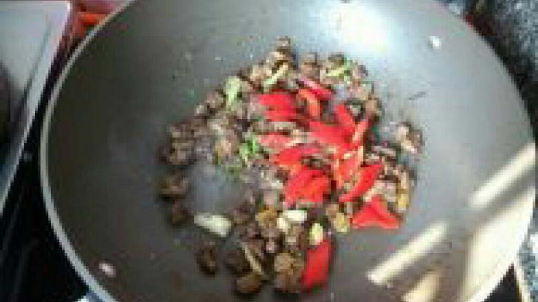 孜然羊肉,翻炒均匀后加入红辣椒，炒至辣椒变软。