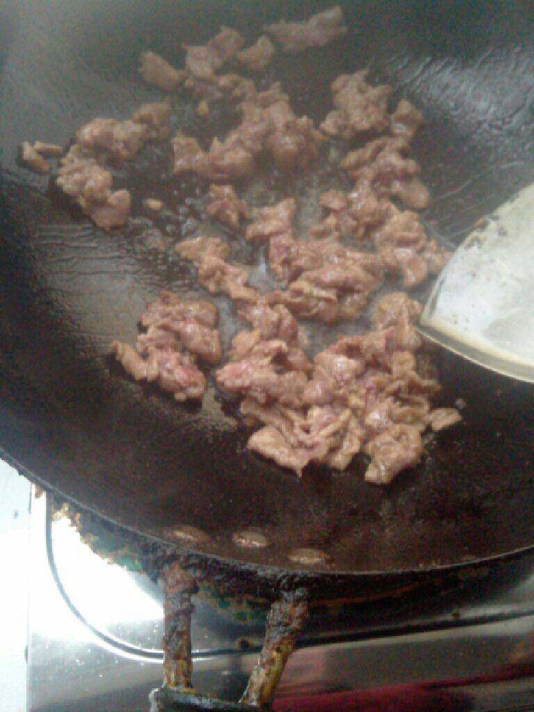 菠萝饭,锅里热油下入腌好的肉翻炒至变色盛起
