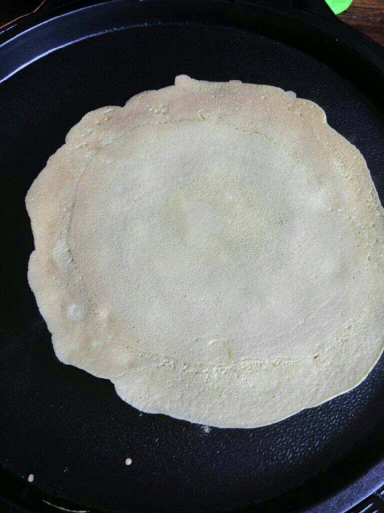 蛋卷饭,拌匀的鸡蛋面倒入锅里摊成蛋饼