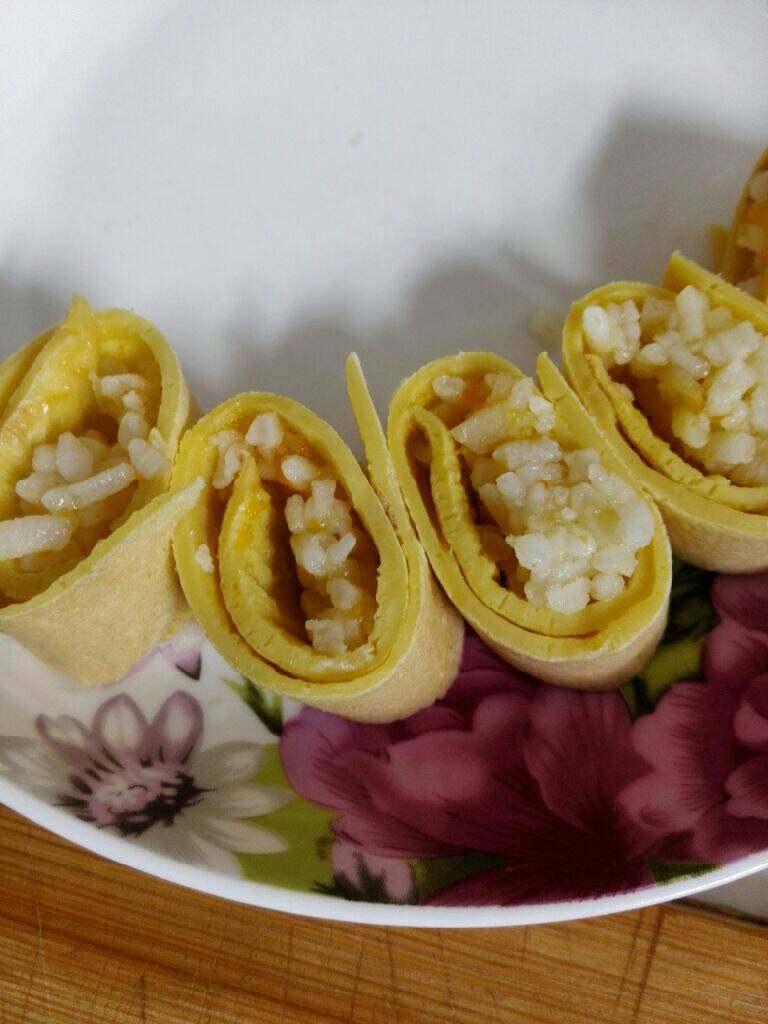 蛋卷饭,煮好的饭捏成卷放入鸡蛋饼上卷起来切段即可，因为不粘粘，为了美观可以用牙签插起来