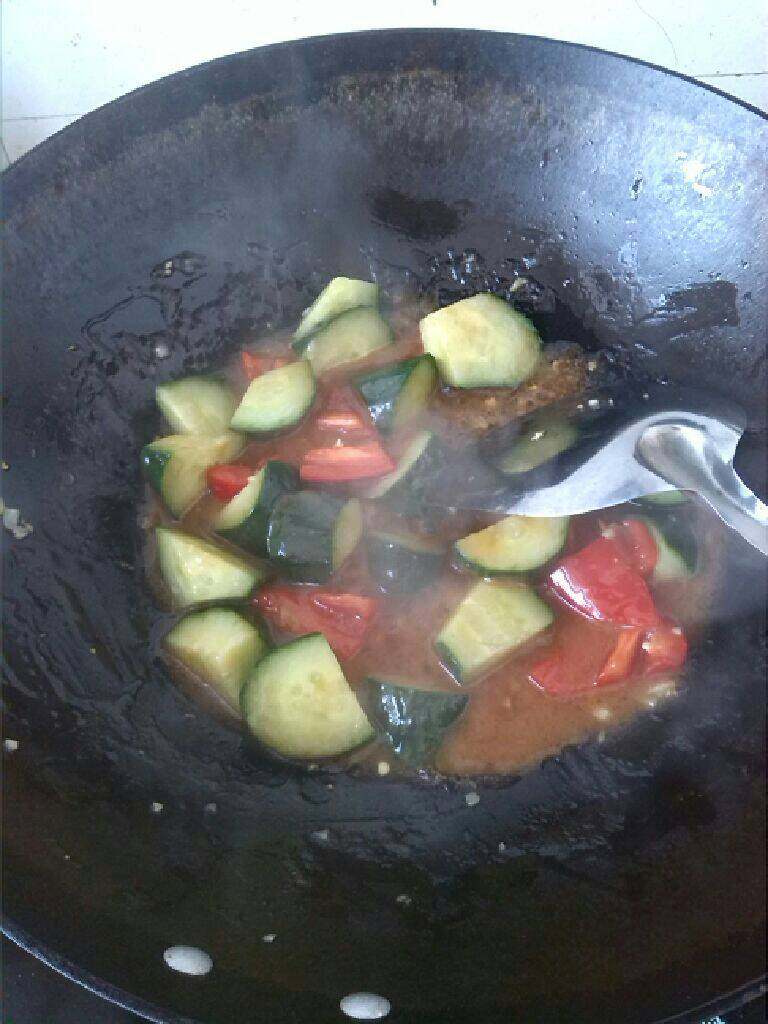 ≈糖醋菠萝排骨≈,锅里留底油，放入黄瓜，红甜椒翻炒，再倒入酱汁