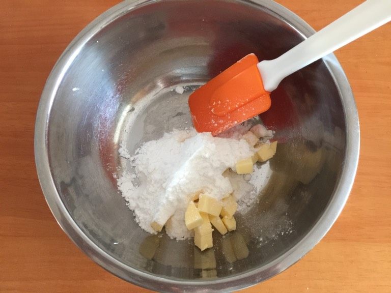 卡通饼干,如图把软化好的黄油加入糖粉,先用刮刀拌匀,防止一会儿用打蛋器打发时,糖粉四处飞溅。