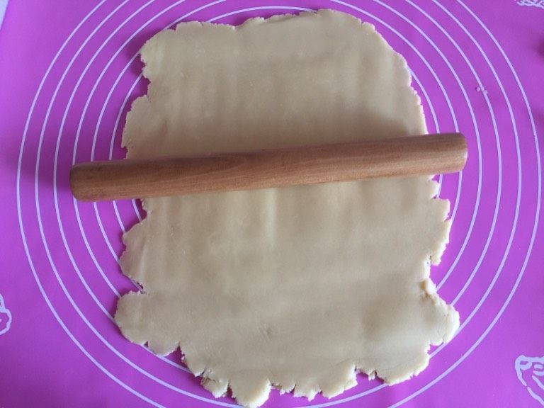 卡通饼干,如图用擀面杖将面团擀成3mm厚的面皮,可以把保鲜膜盖在面团上,这样擀起来不粘。