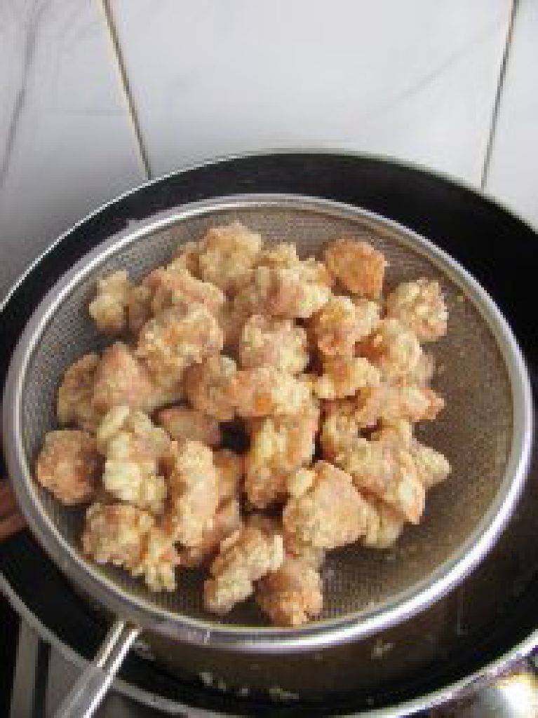 菠萝咕噜肉,然后再次复炸一次。金黄捞出沥油。可放在吸油纸上吸出油份。