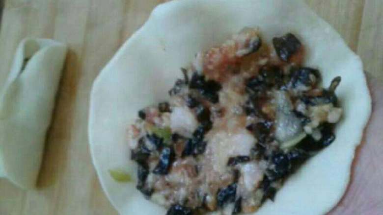 猪肉木耳饺子,包入肉碎,对折捏合中间。