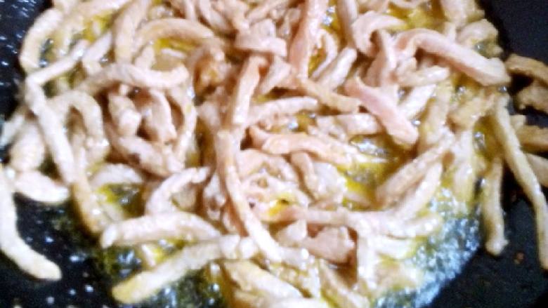 香菜肉丝,锅中加入适量熟豆油,热后加入肉炒至变色。