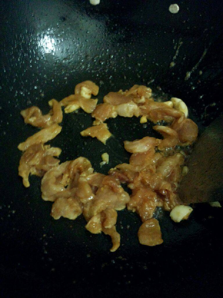 瘦肉日本豆腐炒韭黄,锅在次烧热把蒜放入爆香在把腌制好的瘦肉放入炒