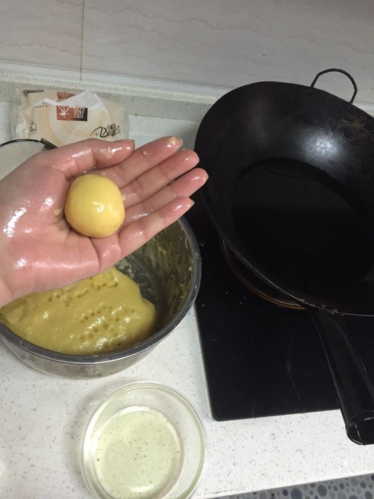 奶油炸糕,在锅中倒入适量油烧热，准备一个小碗 ，倒入食用油 ，用手搓圆面球，沾点油，防止面球与手粘粘，然后放入油中炸