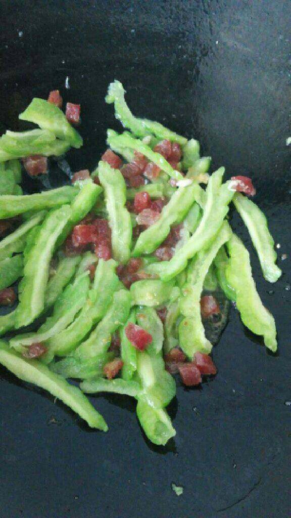 苦瓜腊肠炒饭,炒锅再加油，把腊肠稍微煎一下，倒入苦瓜，加点盐，加点<a style='color:red;display:inline-block;' href='/shicai/ 717'>味精</a>翻炒