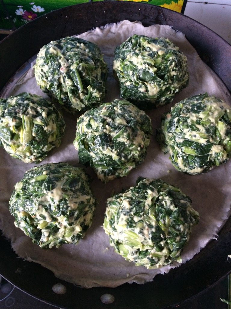 菠菜团子,如图两手沾水，揪出大小合适的菠菜面团，团成团子，放入铺了蒸布的蒸锅里