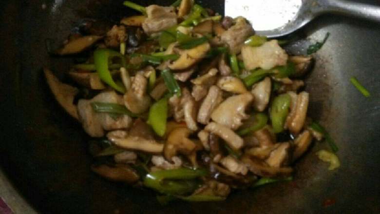 蒜苗香菇炒肉,再加入蒜苗叶翻炒，防止糊锅要加入一点儿清水。加入一小勺生抽和适量盐翻炒均匀。