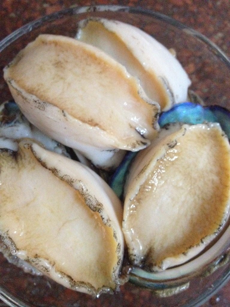 鲍鱼粥,将鲍鱼用刷子刷洗干净后切成薄片待用