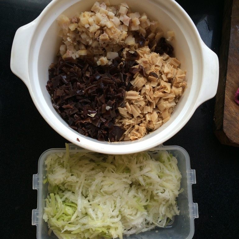 萝卜丝腊肉包子,如图将萝卜擦丝挤出多余水分，<a style='color:red;display:inline-block;' href='/shicai/ 136'>黑木耳</a>，干<a style='color:red;display:inline-block;' href='/shicai/ 7786'>豆筋</a>泡发切丁，腊肉切丁