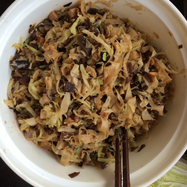 萝卜丝腊肉包子,如图将炒熟的腊肉丁拌入萝卜丝木耳和豆筋中,依次调入少许食盐(腊肉中本身含有咸味),胡椒粉,少许十三香和白糖,搅拌均匀