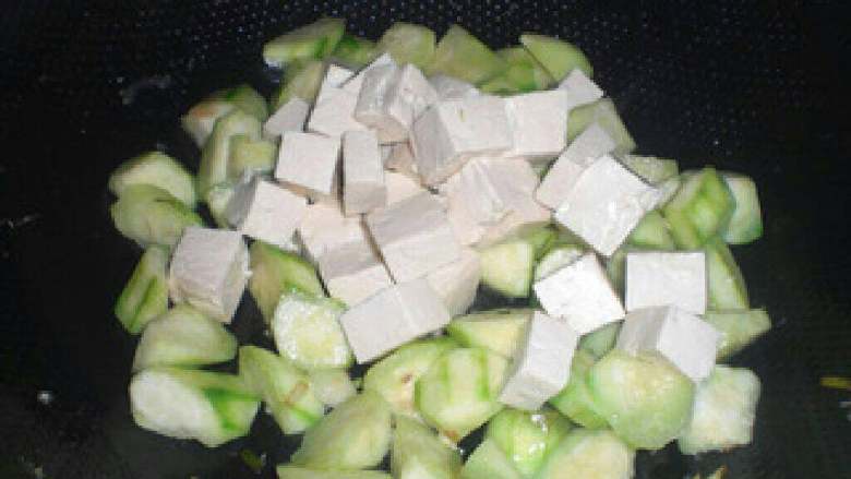 丝瓜鸡蛋豆腐汤,丝瓜炒1分钟后倒入豆腐翻炒。