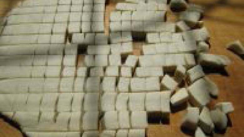 炒疙瘩,面团醒好以后用擀面棍擀成厚片,用刀切成长条,再横着切丁。这时火上烧一锅水