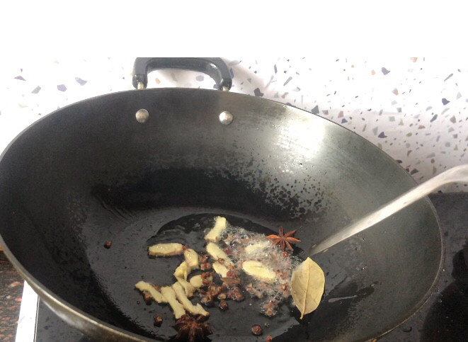 大盘鸡拌面,锅中加入油,放入姜片和香料
小火煸炒香