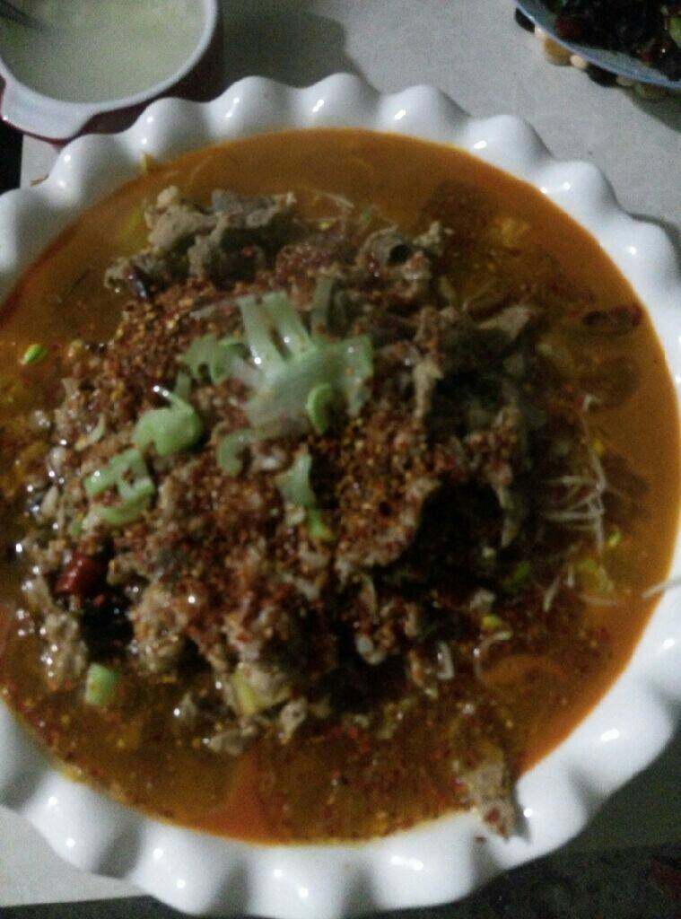 水煮肉片,均匀浇在粗辣椒面上，辣椒和蒜末即出香味，