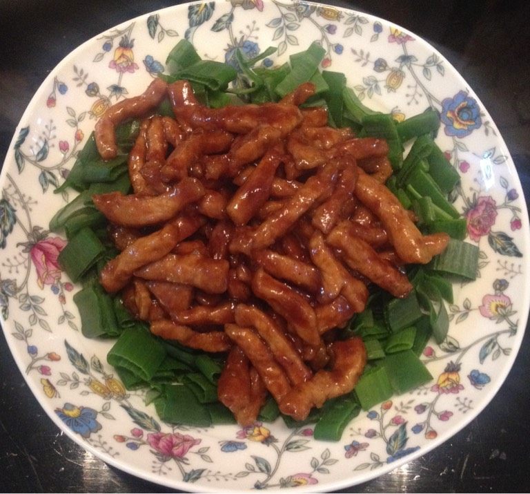 京酱肉丝,将沥好油的肉倒入干净锅中翻炒，倒入酱汁，炒匀，收汁，盛入切好葱叶的盘中