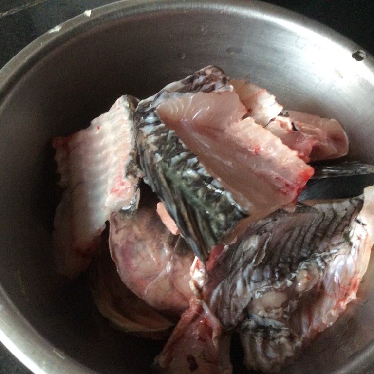 一鱼两食,将罗非鱼冼净,起鱼肉,切片,鱼骨斩件