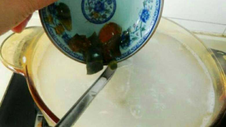 自制咸肉皮蛋粥,锅中放水烧开，放入大米加切碎的皮蛋。