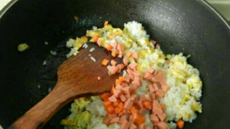 自制火腿炒饭,放胡萝卜 火腿丁，加盐翻炒。