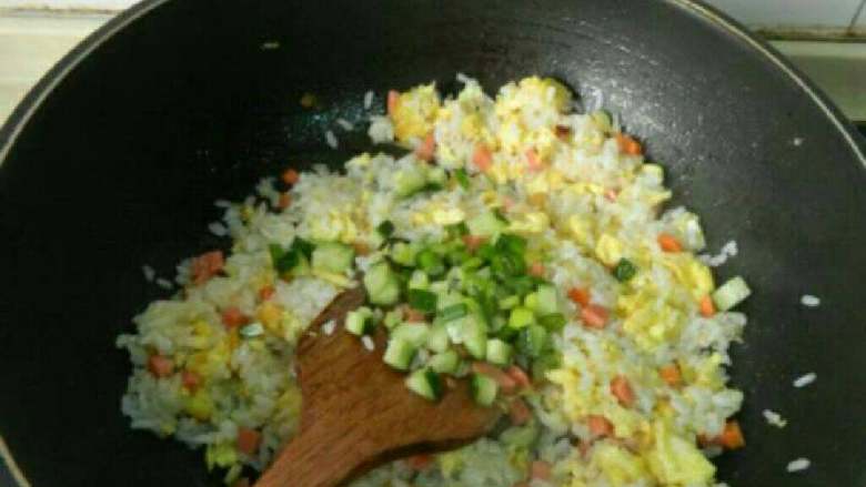 自制火腿炒饭,再放黄瓜和葱花炒匀。