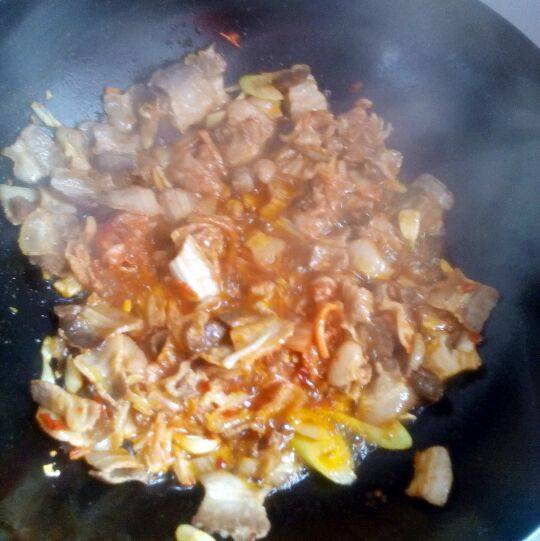 辣白菜炒五花肉蘸豆腐,加入辣白菜和葱花炒两分钟左右。
