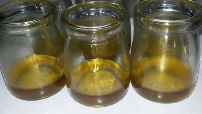 焦糖布丁(简单版),再次用勺子1勺勺装入焦糖已消毒过的杯中。