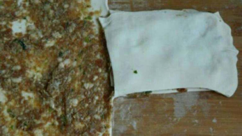 自制千层肉饼,然后把没肉馅的那面面皮盖在中间面皮上,旁边的面皮再盖过来。