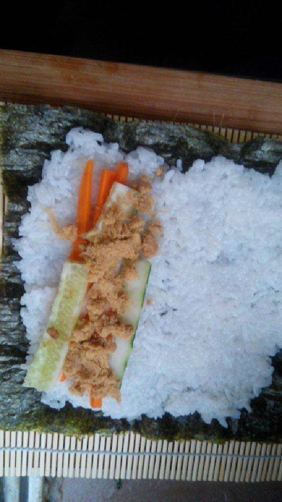 自制寿司,要留出1/3的海苔；黄瓜胡萝卜丝铺上，放入<a style='color:red;display:inline-block;' href='/shicai/ 432'>肉松</a>