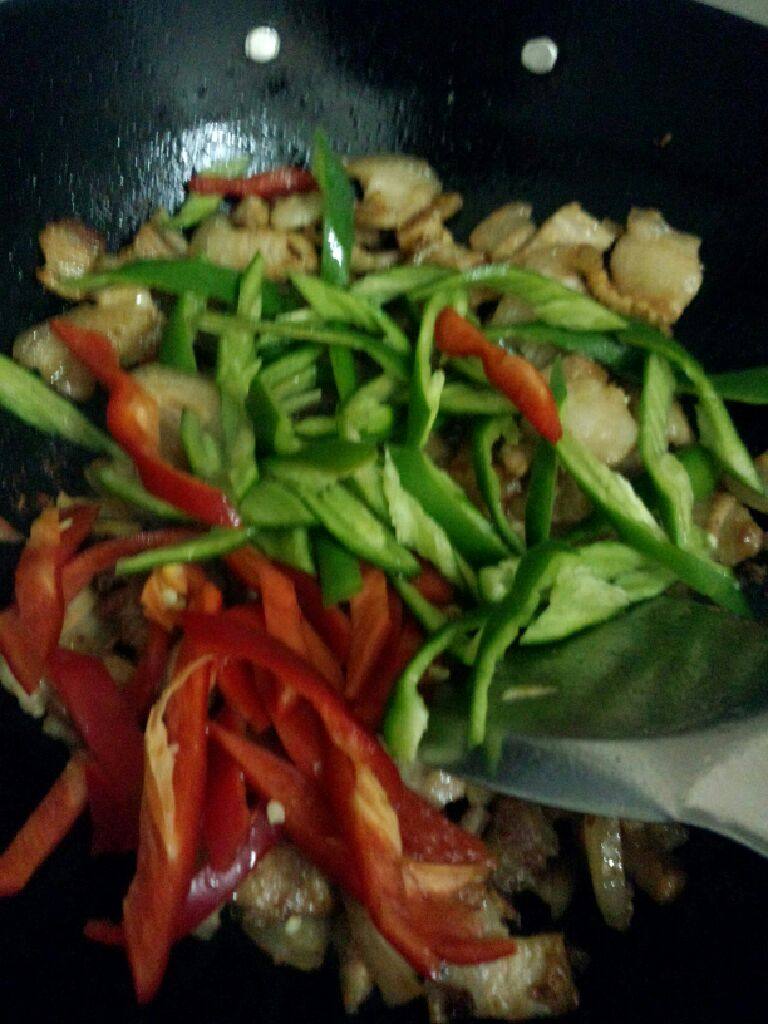 双椒炒五花肉,炒至差不多在把青椒和红椒一起放入炒