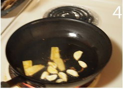 三杯猪脚,另起炒锅，大火下黑麻油起锅，爆香姜片和蒜头，拌炒至蒜头呈焦黄色