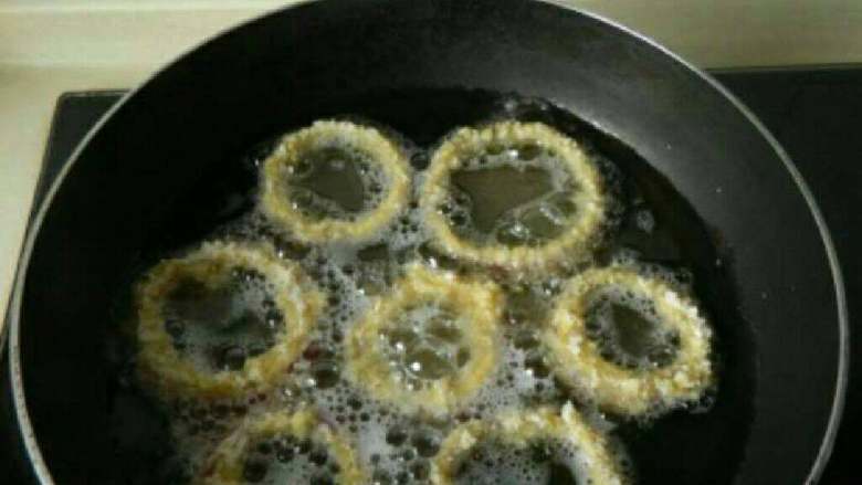 法式洋葱圈,锅中油烧热，放入洋葱圈炸制金黄捞出。