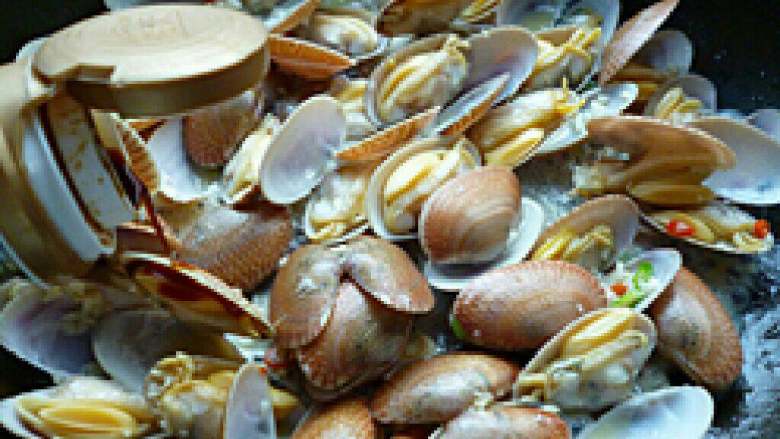 辣炒花蛤,把沥干的花蛤放入锅中,加入料酒,糖,盐,鸡精,盐,快速翻抄,即可出锅