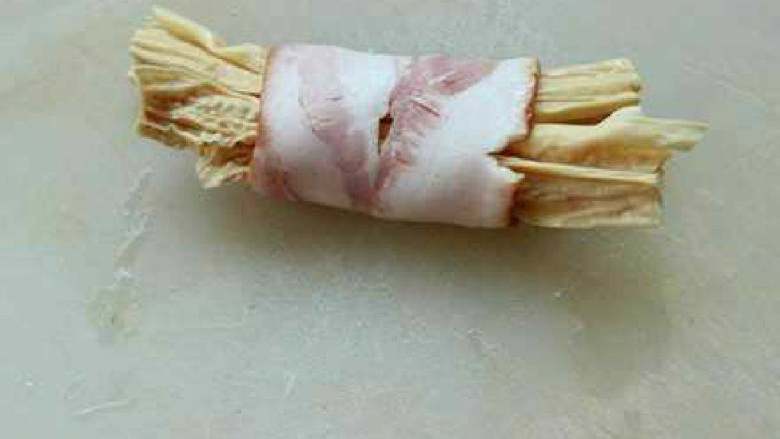 腐竹培根卷,取一片<a style='color:red;display:inline-block;' href='/shicai/ 443'>培根</a>放上腐竹，然后卷起来， 卷好放入盘中。