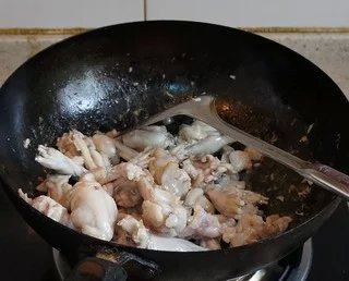 干锅牛蛙,热锅下油,加牛蛙煸炒至断生,起锅备用。