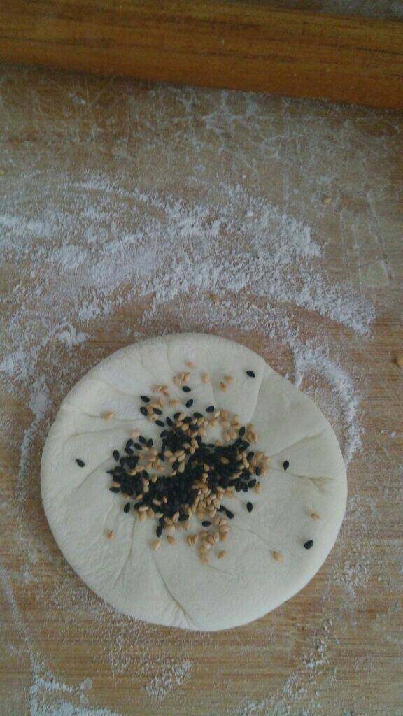家常糖饼,稍微擀一下,撒上白黒芝麻