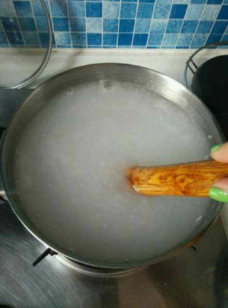 自制绿豆凉粉,5碗水放锅内烧开,一手拿擀面杖,一手拿水淀粉碗,边搅拌边倒入,用擀面杖搅效果好。