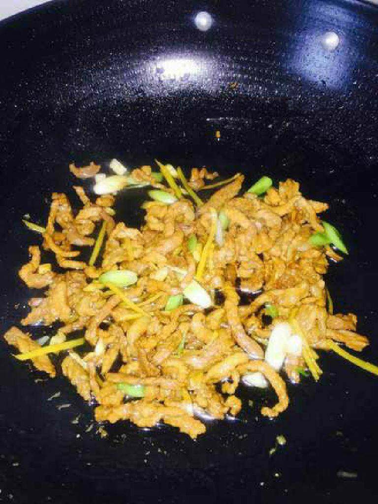 青椒肉丝,肉丝下锅,翻炒至金黄,加入青蒜苗蒜白段继续翻炒几秒。