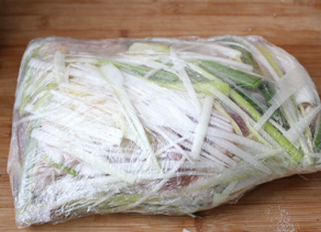孜然烤羊腿,然后两面都用葱姜丝铺满,用保鲜膜包好,进行腌制,一定要腌制24小时以上才能入味