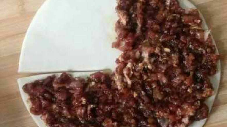 千层肉饼, 在案板上洒一些干面粉,将醒发后的面团取一半,擀成2-3MM厚的大圆饼, 在圆饼的一头切一个口至圆心 薄薄的铺上一层肉馅。