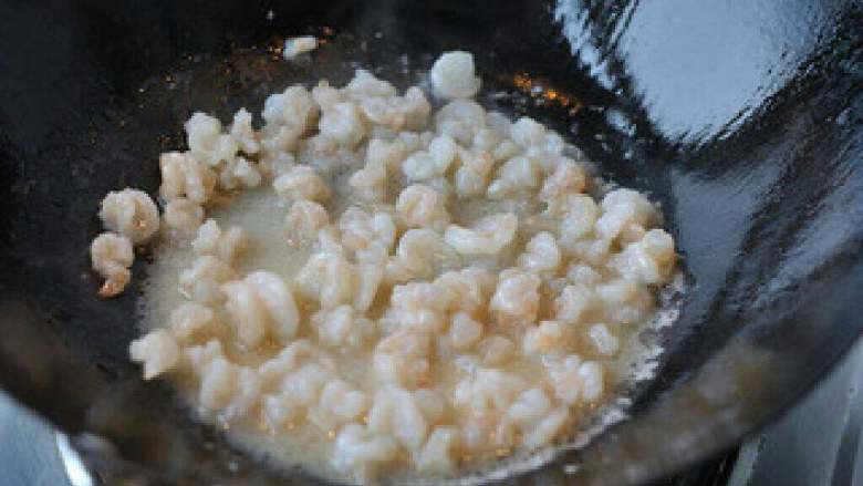 青豆炒虾仁,锅烧热，放入蒜片爆香，倒入虾仁大火快速翻炒
